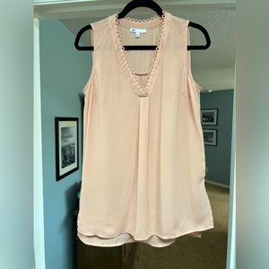Soft pink sleeveless blouse.